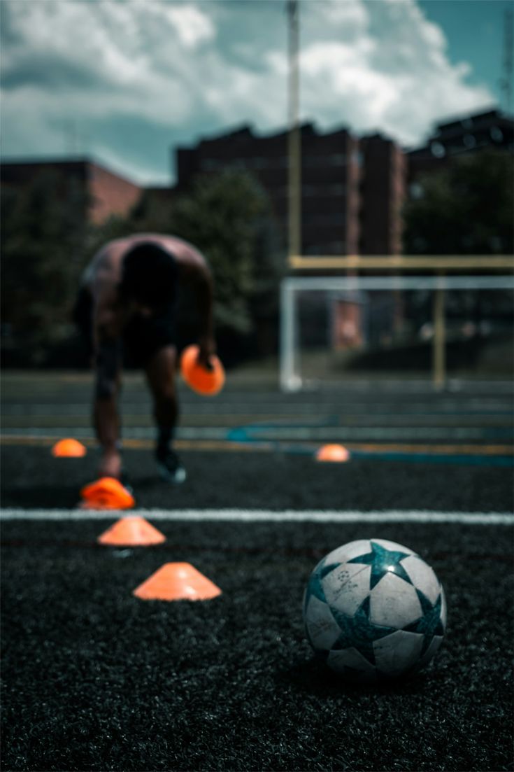 Treino com cones e bola em primeiro plano
